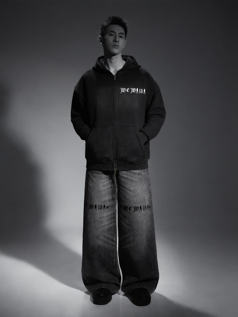 Model in a black We Wildin zip hoodie and wide-leg washed denim, studio light