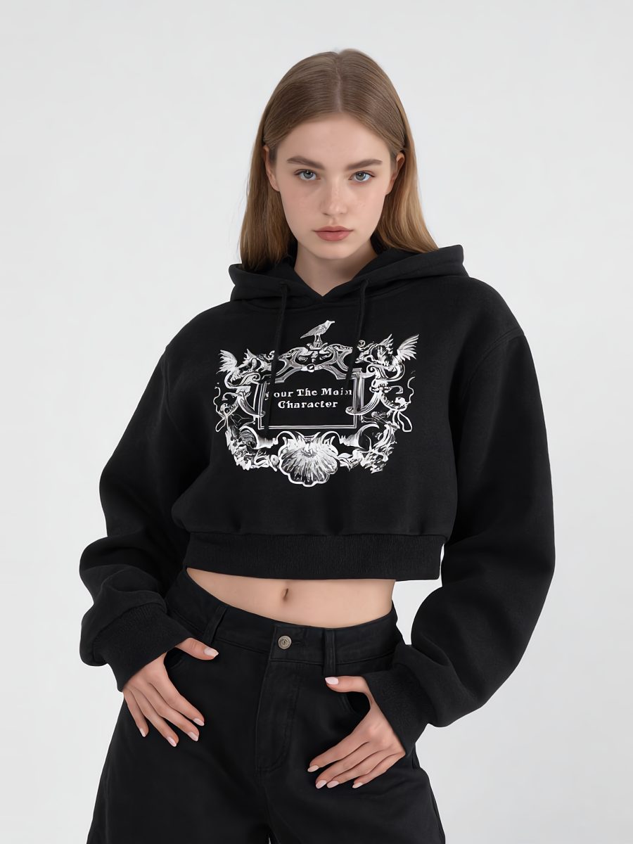 Model in a black cropped 'Your The Main Character' hoodie