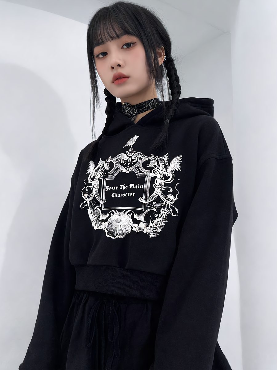 Close-up of a model in a black graphic hoodie with braided hair