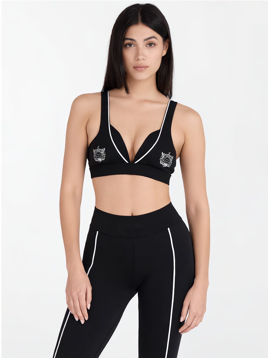 Model in a black halter sports bra and matching leggings