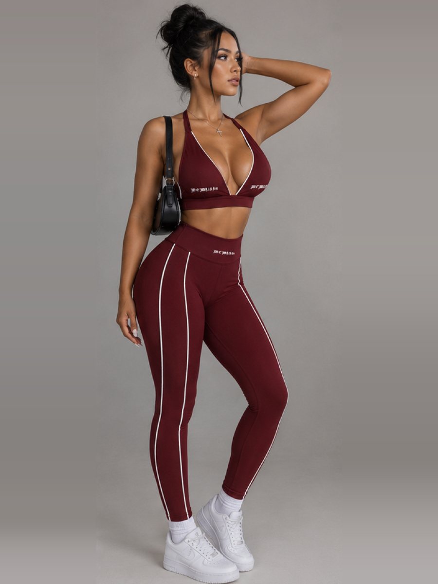 Model posing in the burgundy halter sports bra and leggings set